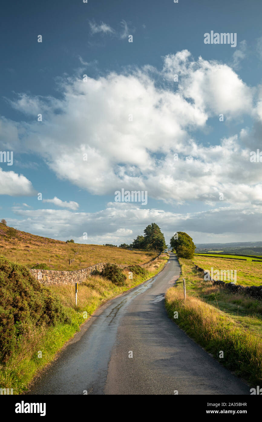 Empty asphalt countryside road across at warm summer evevning in Peak District National Park, UK Stock Photo