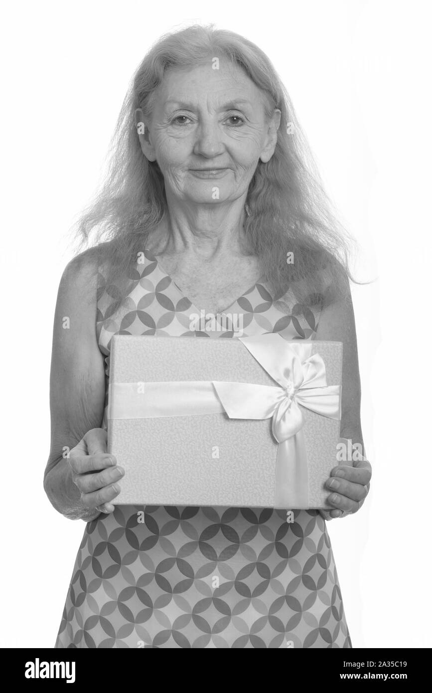 Studio shot of senior woman holding gift box Stock Photo