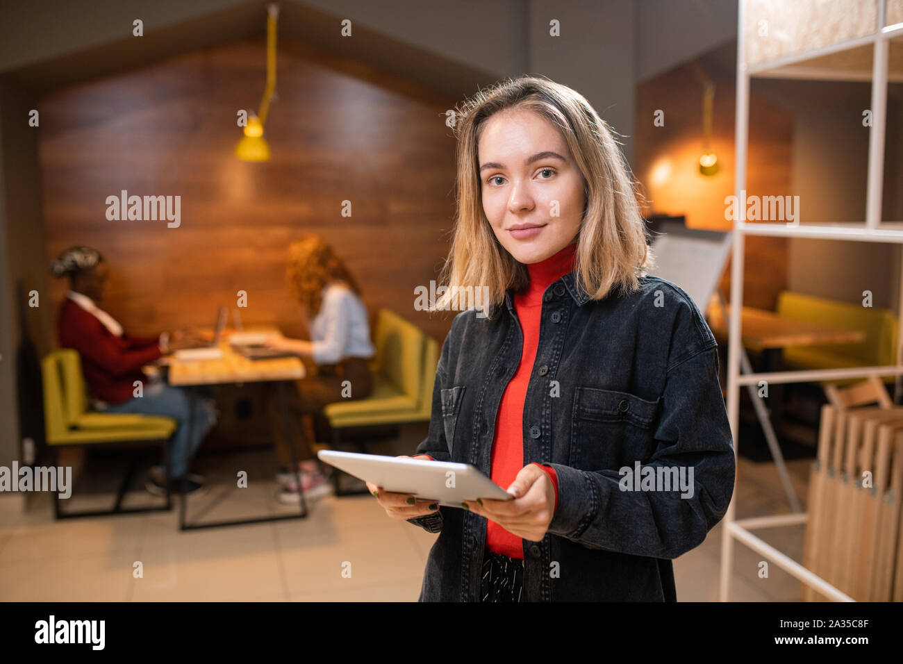 Pretty young successful student using touchpad while preparing homework Stock Photo