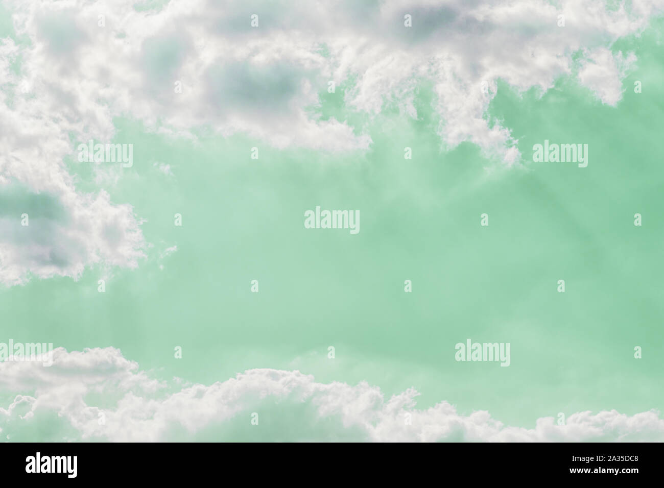 Delicate light rays through clouds on a pastel green color sky ...