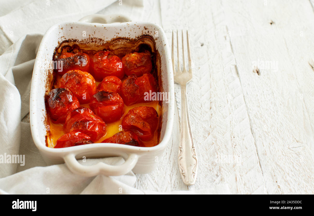 Roasted cherry tomatoes in a small casserole close up Stock Photo