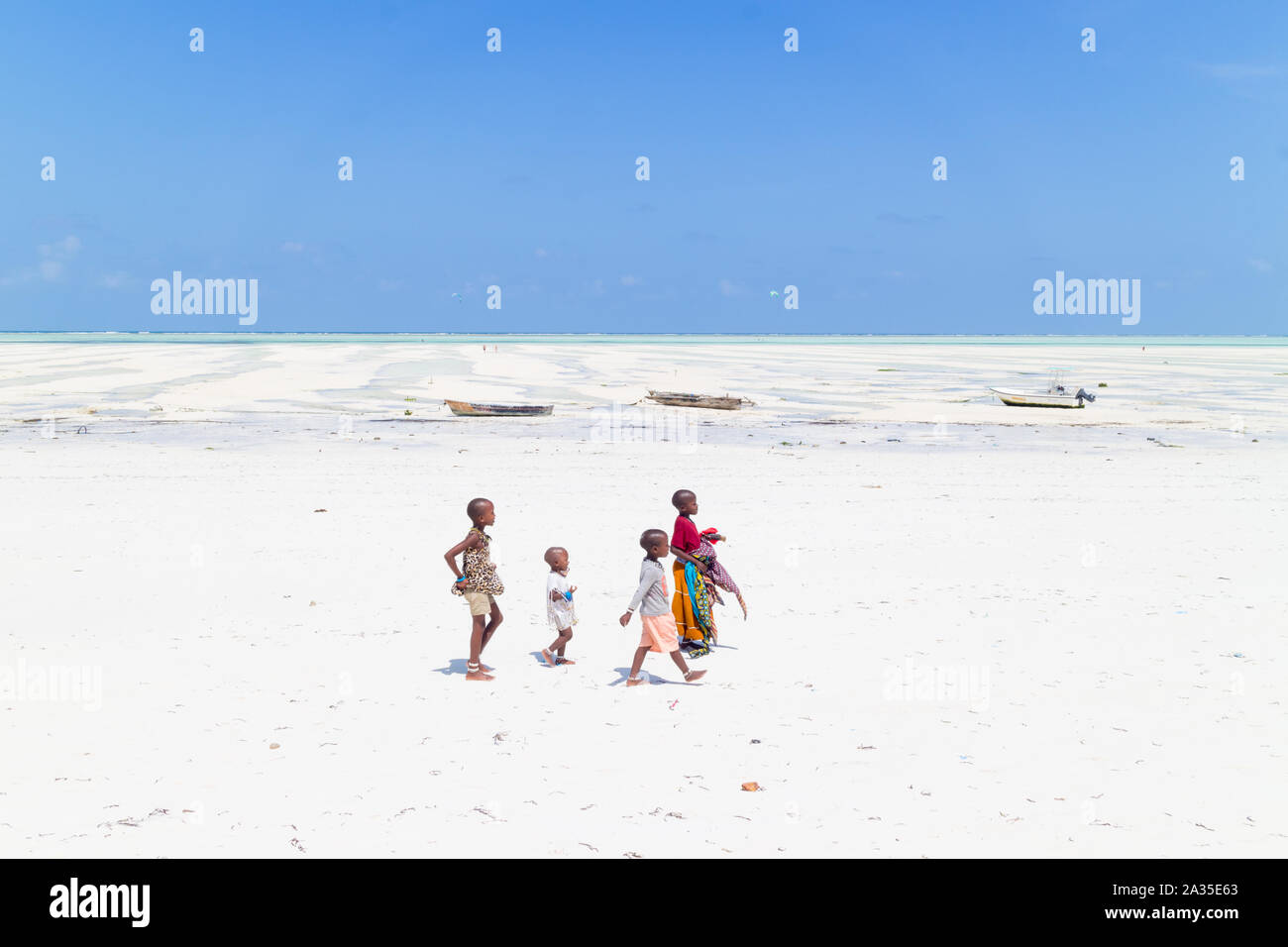 Paje, Zanzibar - Feb 9, 2015: Local kids walking at Paje village picture perfect white beach at low tide on February 9th, 2015 on Zanzibar, Tanzania Stock Photo