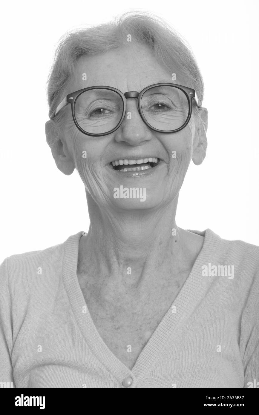 Face of happy senior nerd woman smiling while wearing geeky eyeglasses Stock Photo