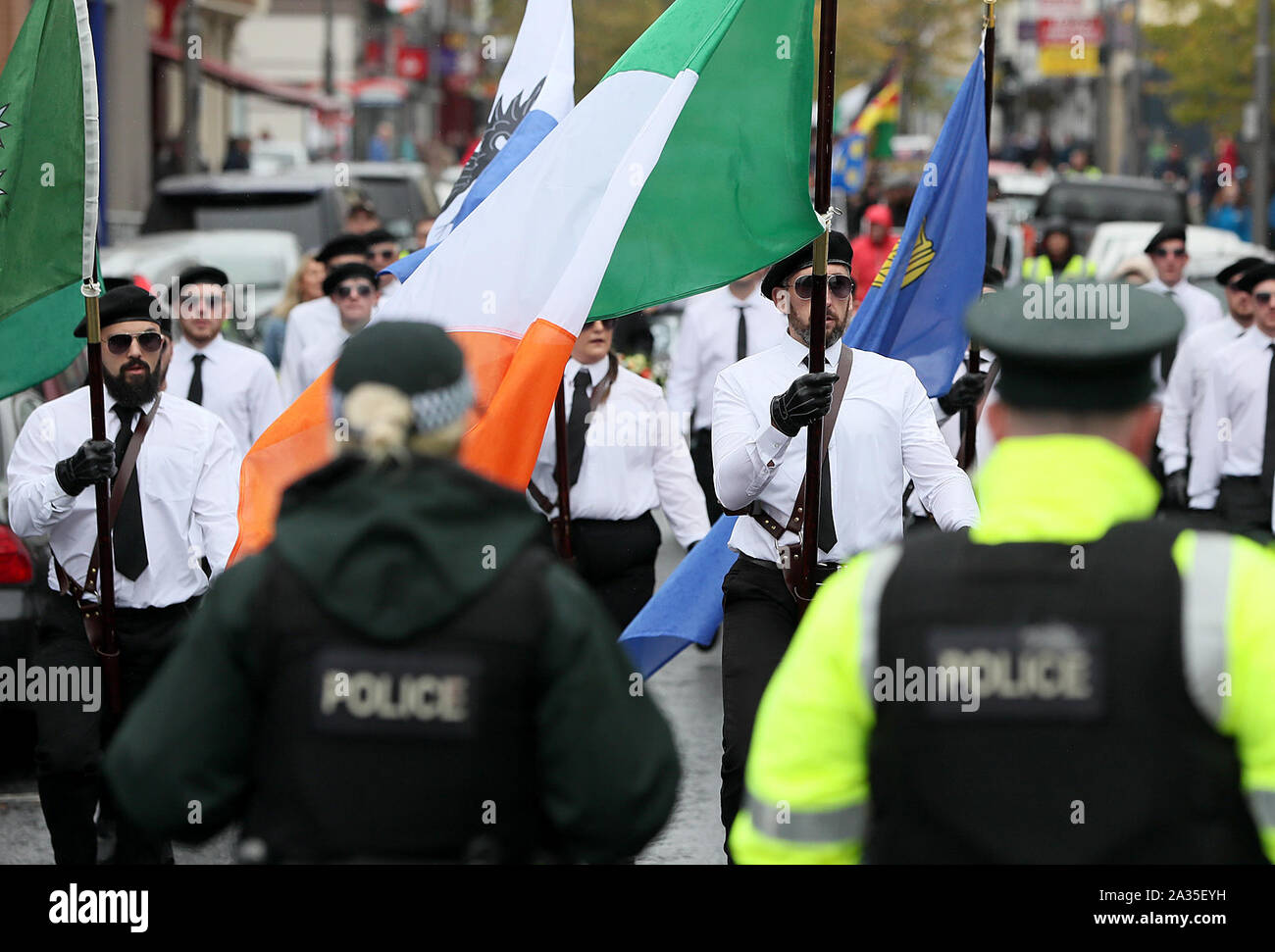 PSNI officers watch as a colour party takes part in a parade in Newry, Co Down. The political party Saoradh had organised the parade to commemorate hunger strikes. Stock Photo