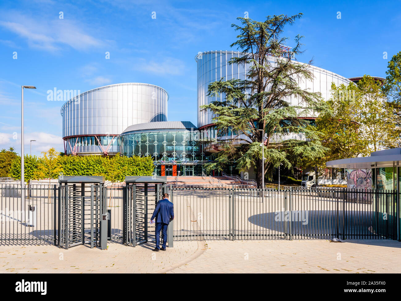 A man in blue suit is passing the security turnstile to enter the building of the European Court of Human Rights in Strasbourg, France. Stock Photo
