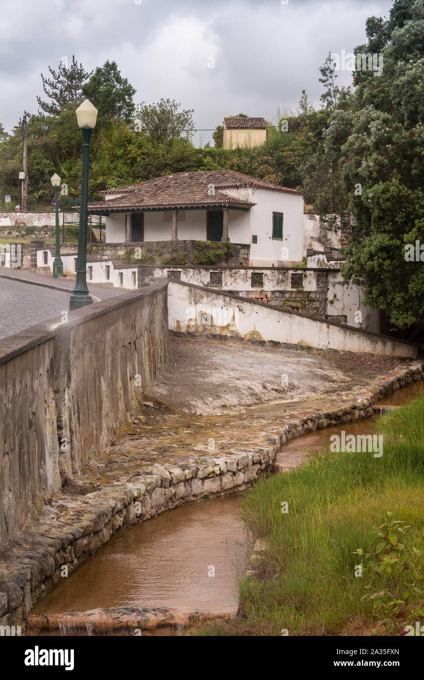 River from the hot sulphur springs, among a road and a forest. Building