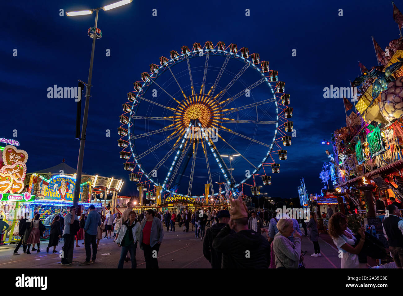 Munich, Germany - 2019, September 28: visitors from all over the world walking in front of the ferris wheel at the Oktoberfest in Munich. Stock Photo