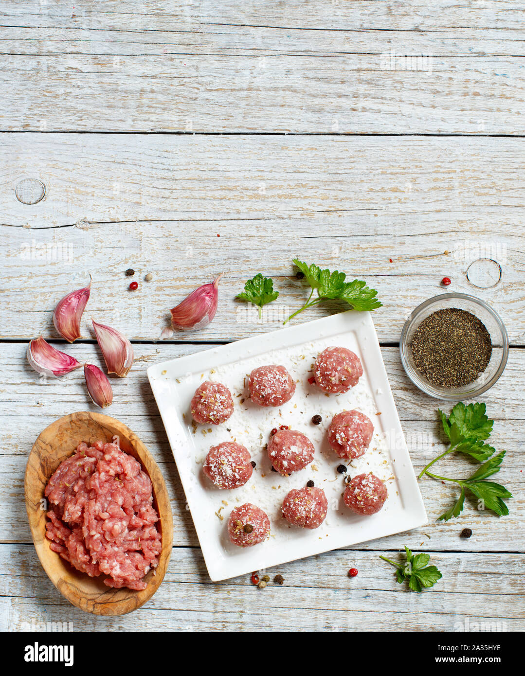 Raw  meatballs with vegetables and herbs on a table Stock Photo