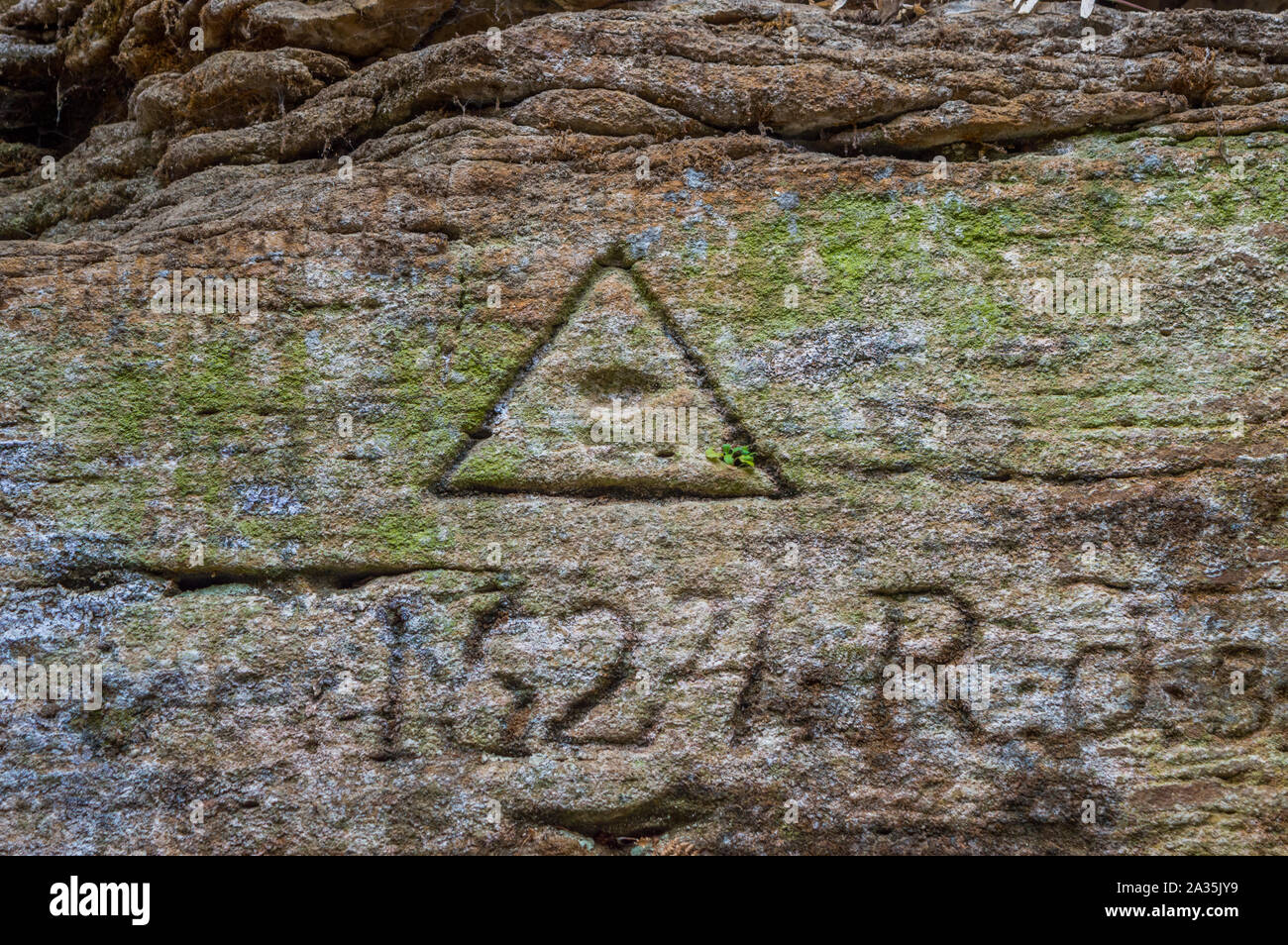 Eye of Providence Carved into Stone Wall in Ancient Cave Stock Photo