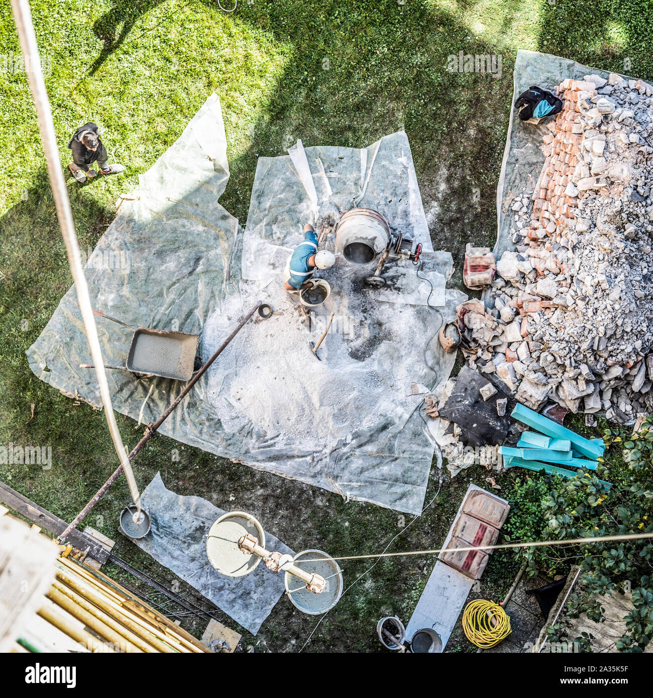 Top view of authentic builder men working with shovel during concrete