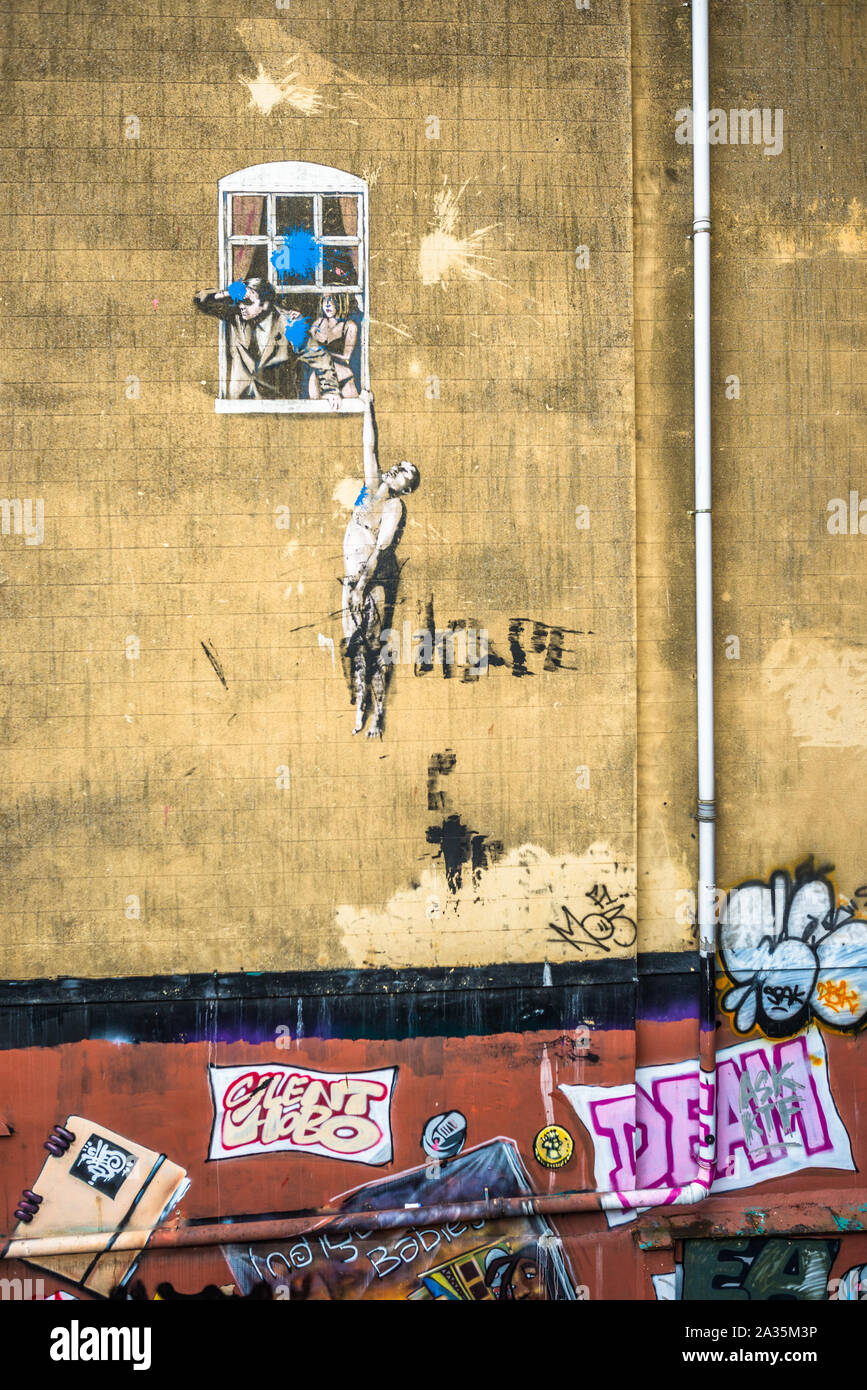Artwork by Banksy known as Well Hung Lover, Naked Man Hanging From Window, or just Naked Man, on Frogmore Street, Bristol, England, UK. Stock Photo