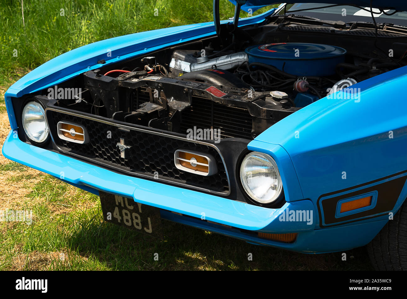 The front of a blue 1971 Ford Mustang on display at a car show Stock Photo