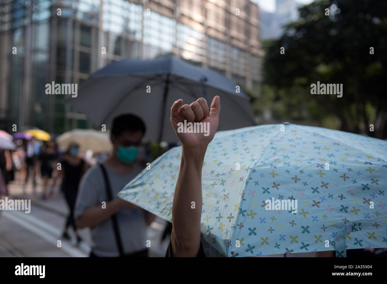 A protester holds her hand up in reference to the now '6 demands' protesters have for the government.Protesters participated in spontaneous rallies and marches all across Hong Kong in response to the recent anti-mask law passed the previous day. Marches and rallies during the day were largely uninterrupted by police, although riot police conducted several dispersal operations at night. Stock Photo