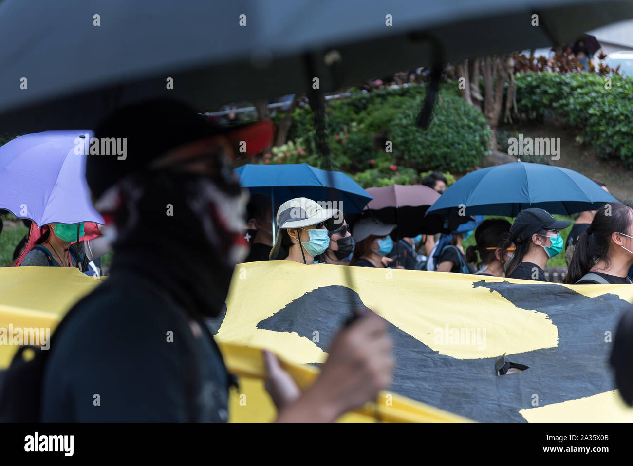 Protesters carry a banner as they march through the streets in opposition to the anti-mask law.Protesters participated in spontaneous rallies and marches all across Hong Kong in response to the recent anti-mask law passed the previous day. Marches and rallies during the day were largely uninterrupted by police, although riot police conducted several dispersal operations at night. Stock Photo