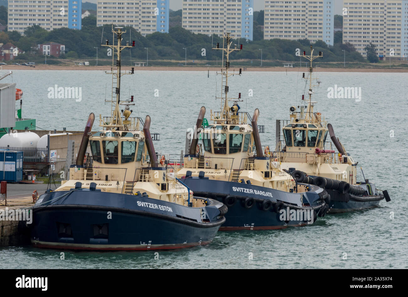 tugs or tug boats next to the vessel traffic services building in the