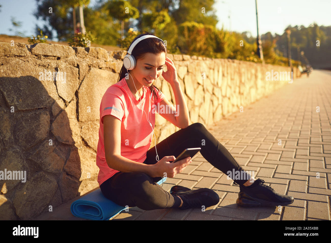 A sports girl in headphones is resting listening to music after training Stock Photo Alamy