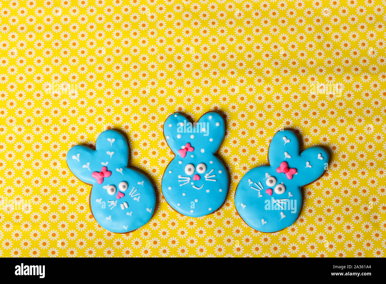 Easter funny rabbits, homemade painted gingerbread biscuits in glaze on a yellow background Stock Photo