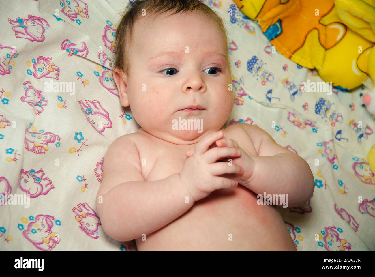 Adorable two month old baby girl lying on the pillow and looking into