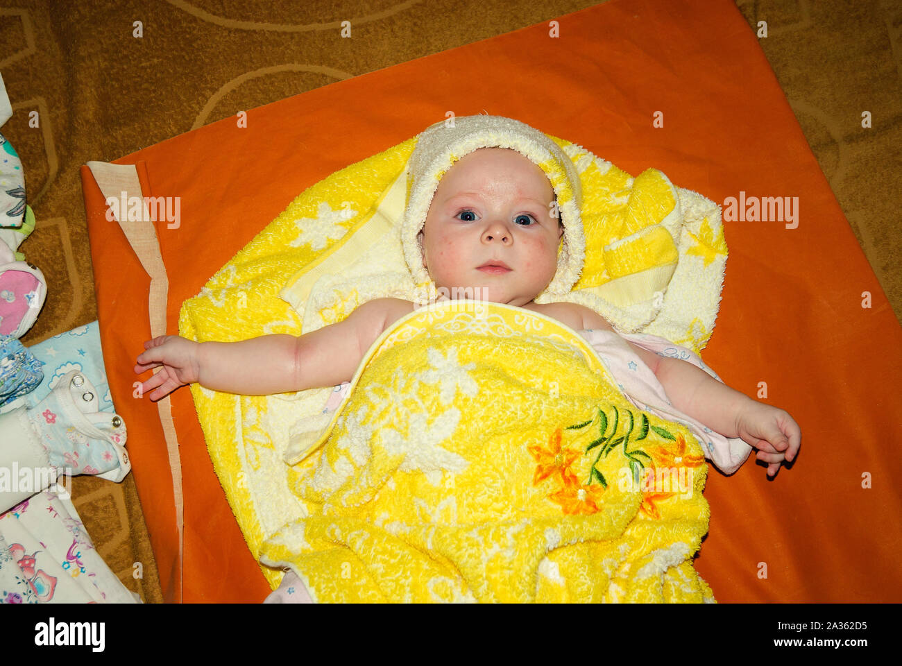 Adorable Two Month Old Baby Girl Lying On The Pillow And Looking Into