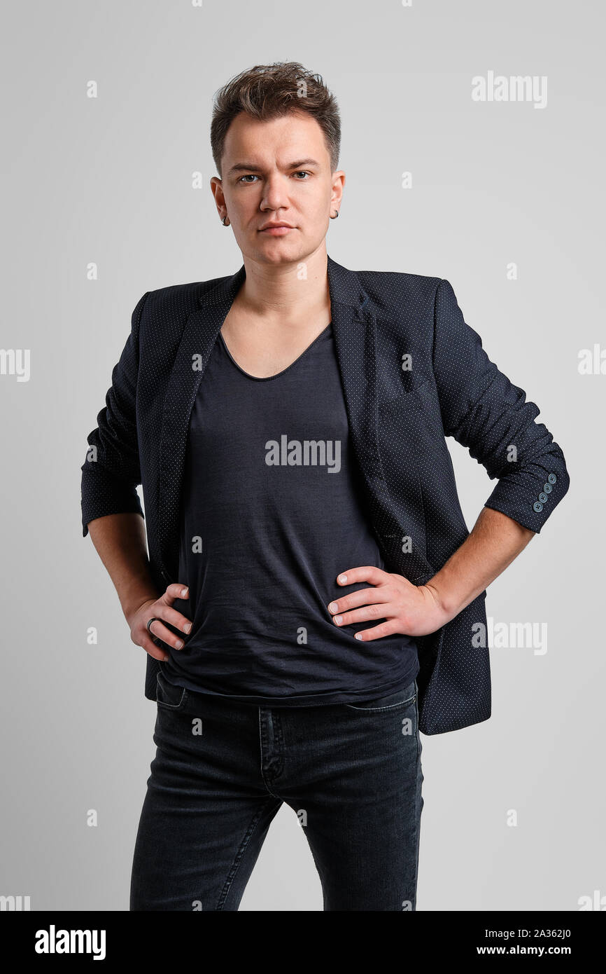 Portrait of serious man in jeans, t-shirt and fitted jacket with hands on waist Stock Photo