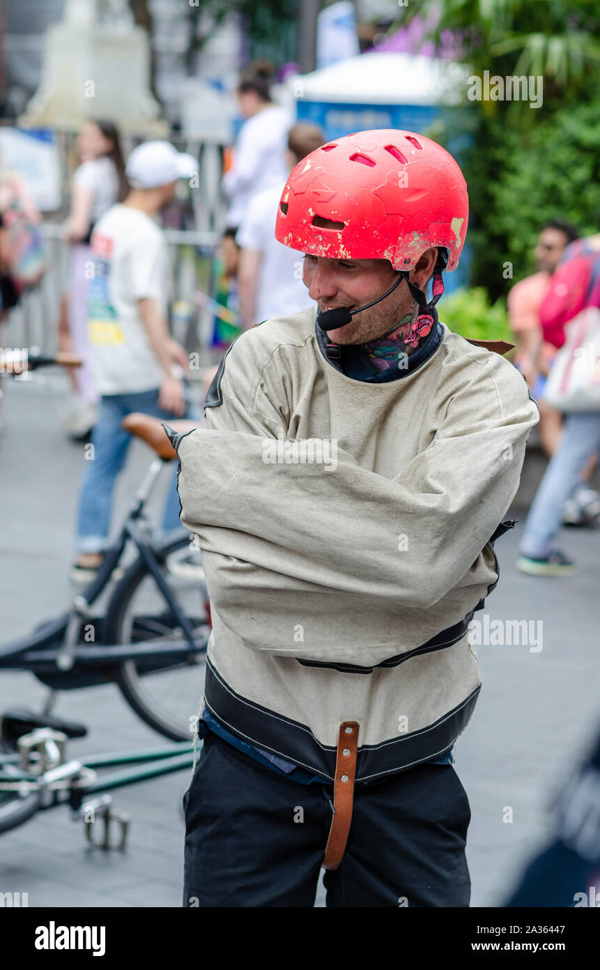 Street artist in a strait jacket shows Houdini style magic tricks, where he performs escape act. Taken in London streets during the Gay Pride. Stock Photo