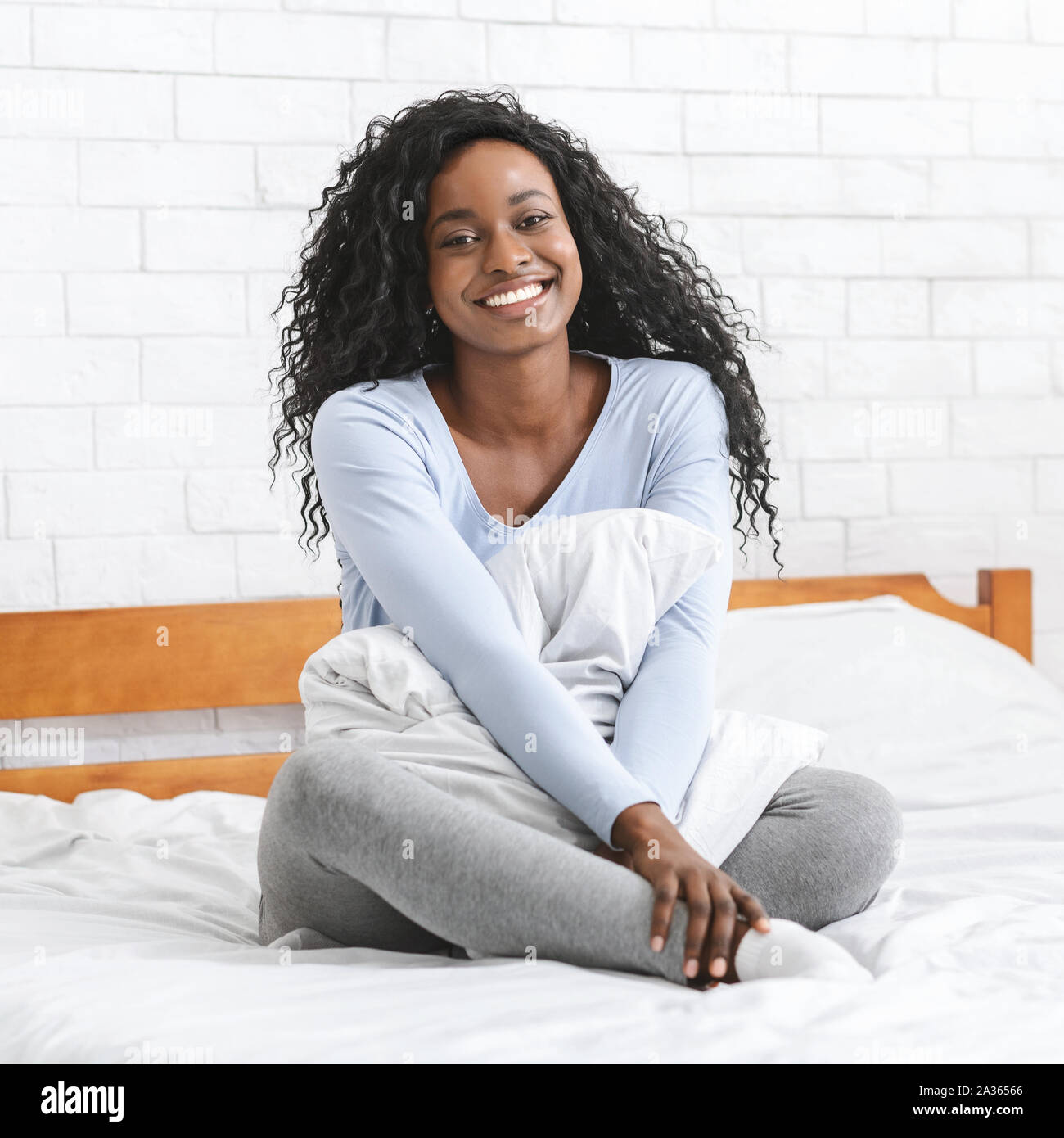 Portrait of pretty woman sitting on bed Stock Photo - Alamy