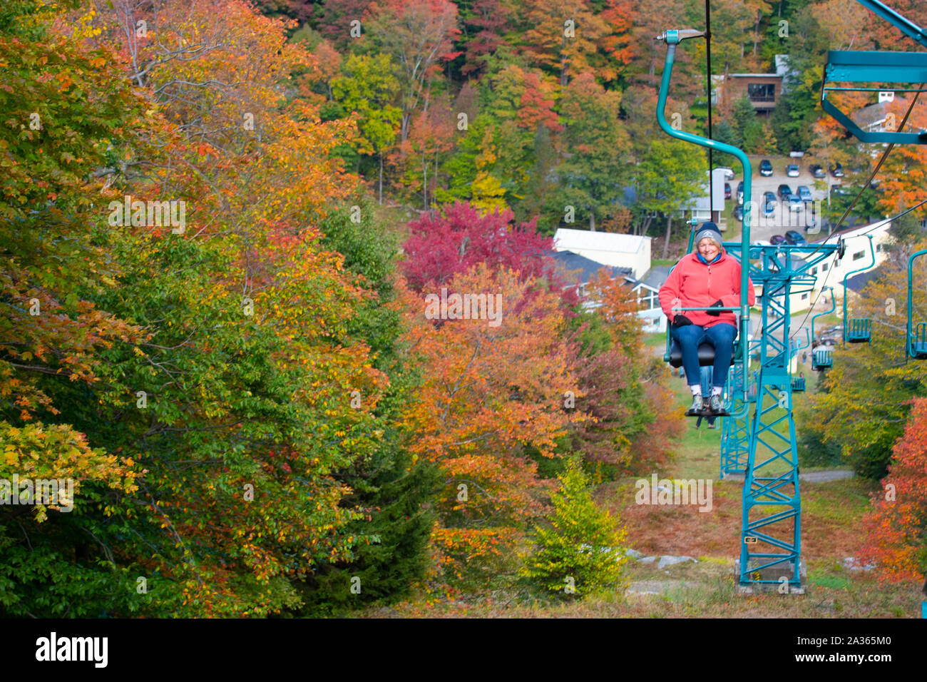 Deborah Slinn of Fayston, Vermontrides the single chair at the MadRiver Glen ski area in Fayston, Vermont, USA 10/51019 during green and gold weekend Stock Photo