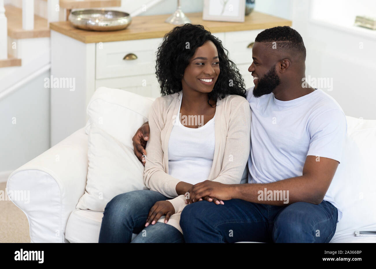 Portrait Of Couple In Love Sitting On Sofa At Home Stock Photo - Alamy