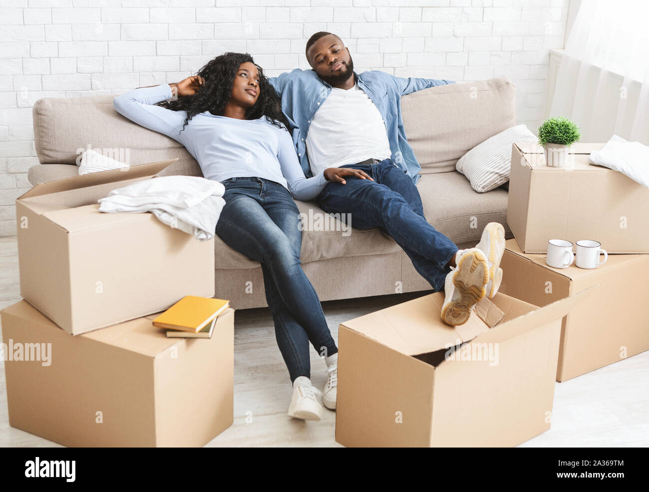 Couple On Couch Taking Break From Unpacking On Moving Day Stock Photo Alamy
