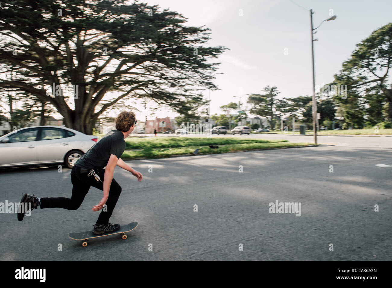 Young Man Skating in the Street in a Residential neighborhood Stock Photo