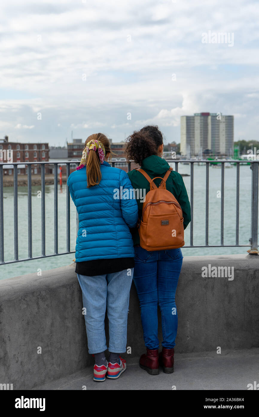 A pair of young female multicultural tourists looking out to see from a view point Stock Photo