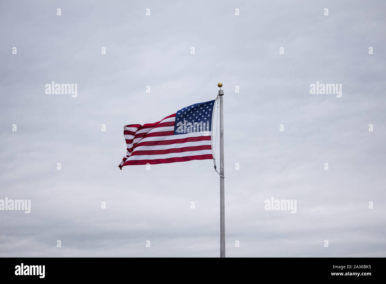 American flag flying from pole on overcast day Stock Photo - Alamy