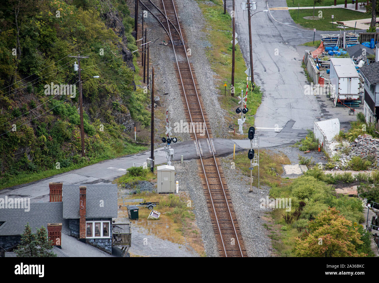 Single railroad track crossing through rural American town Stock Photo