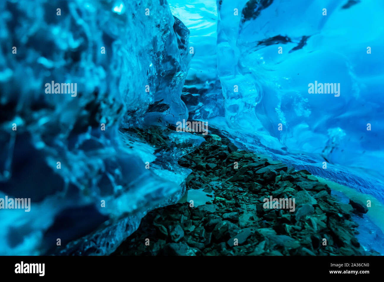 A narrow canyon cuts this ice cave below the Salmon Glacier in Canada. Ice turns blue deep within the glacier and only the blue wavelength passes thro Stock Photo