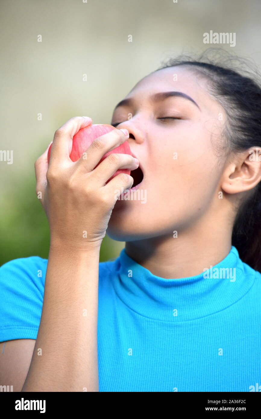 A Young Woman Eating With Apples Stock Photo