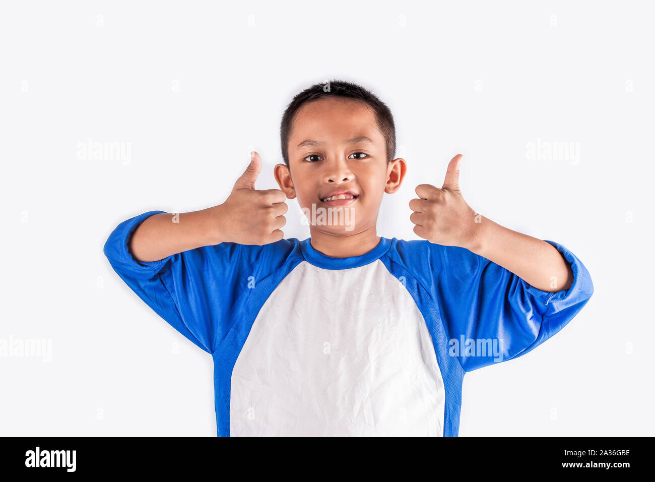 Cute little boy showing thumb up with smiley face. Lovely boy feel happy and relaxed. He has good health and enjoy life. Stock Photo
