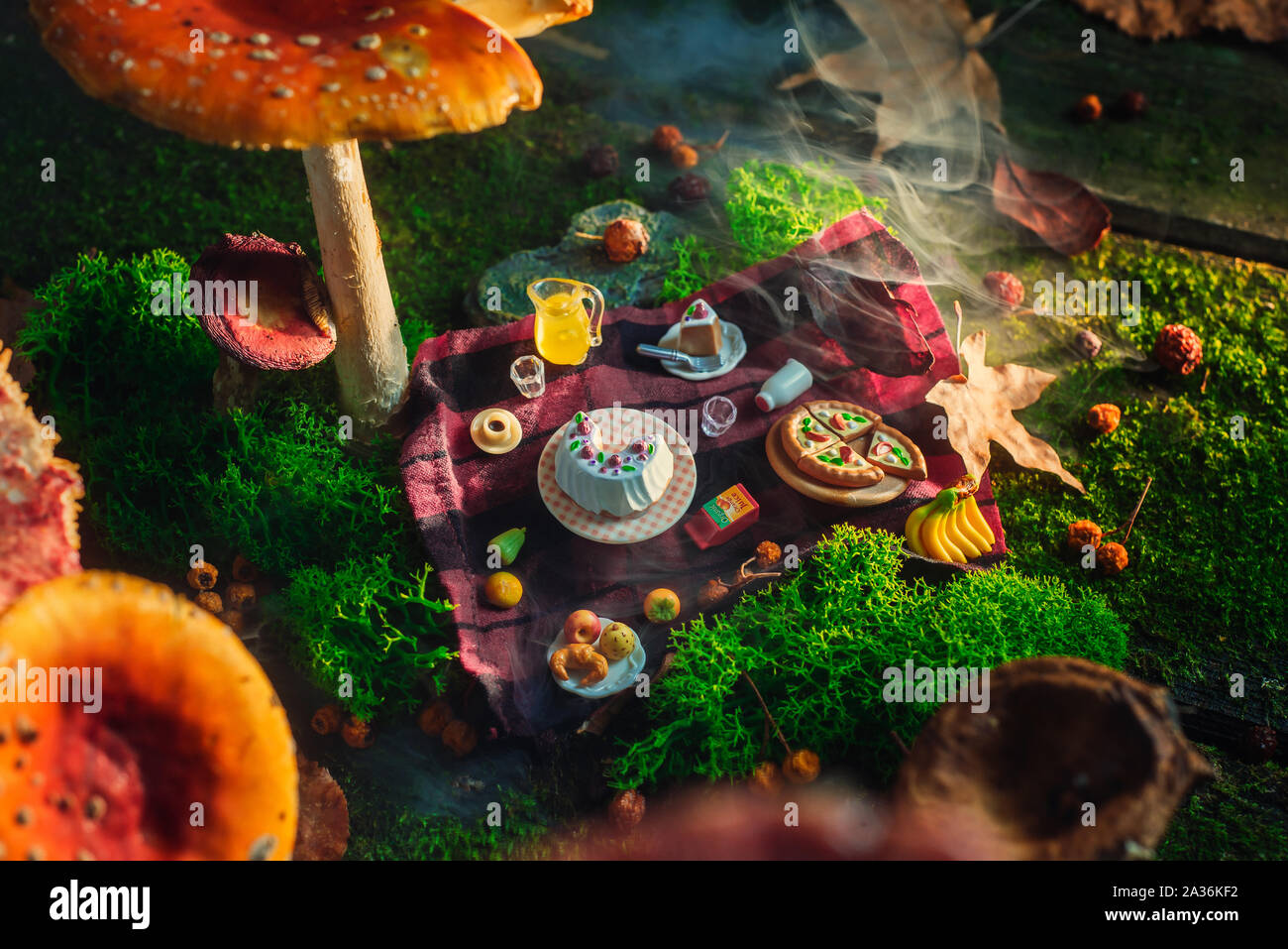 Picnic under toadstool mushroom, miniature food in the forest, tiny world concept. Magical art photo header. Stock Photo