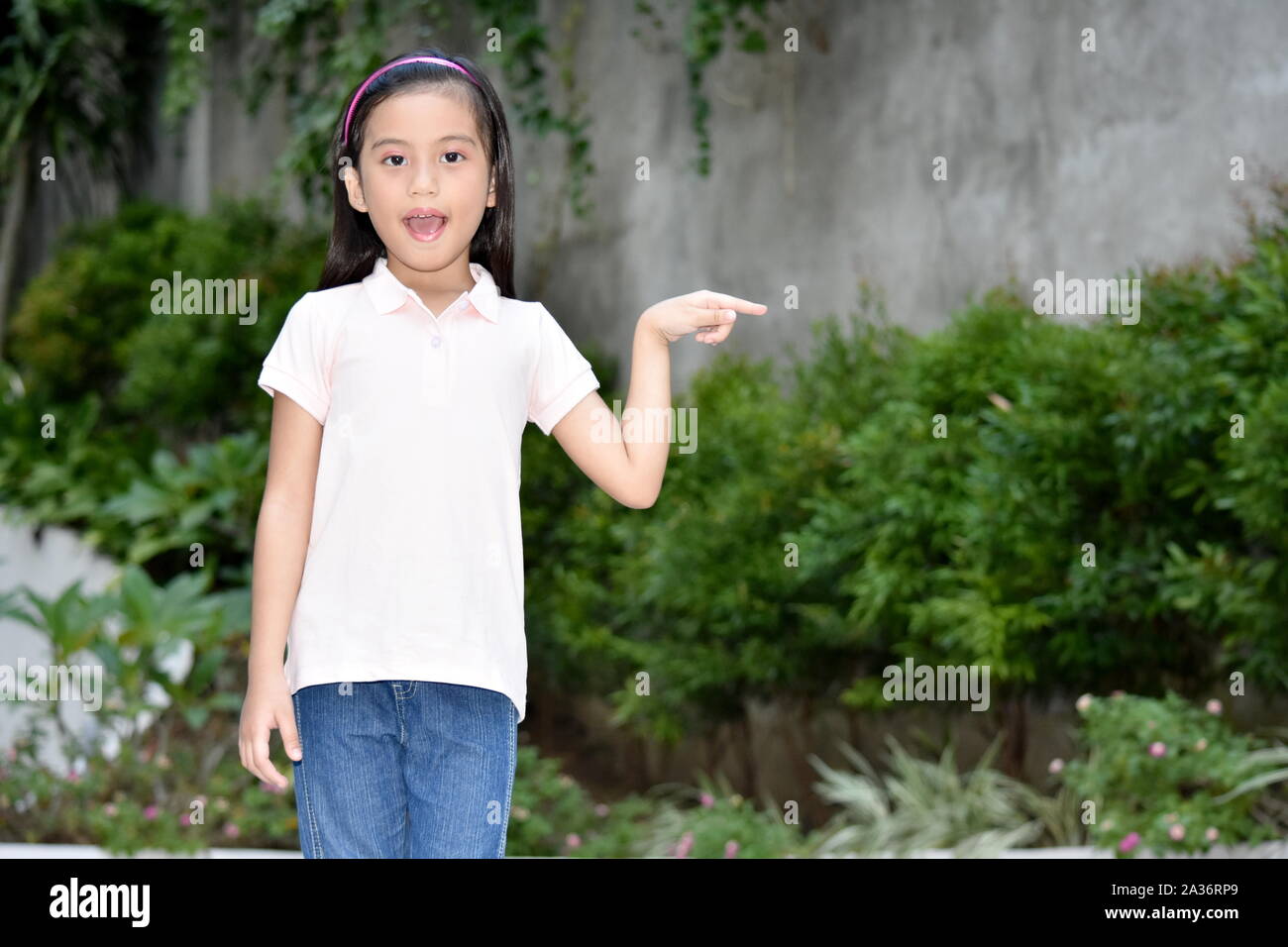 A Young Filipina Preteen Pointing Stock Photo