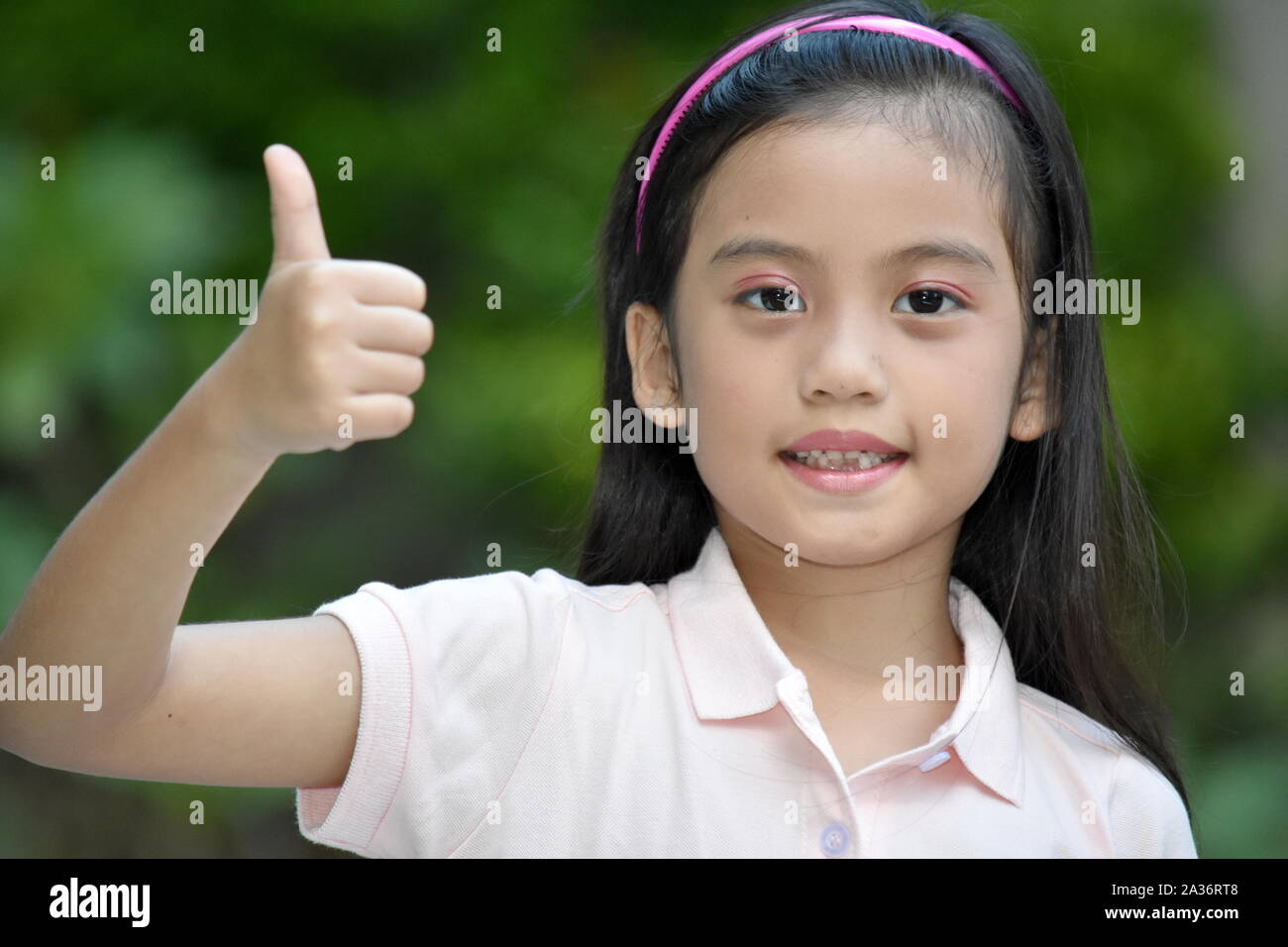 An Asian Preteen With Thumbs Up Stock Photo