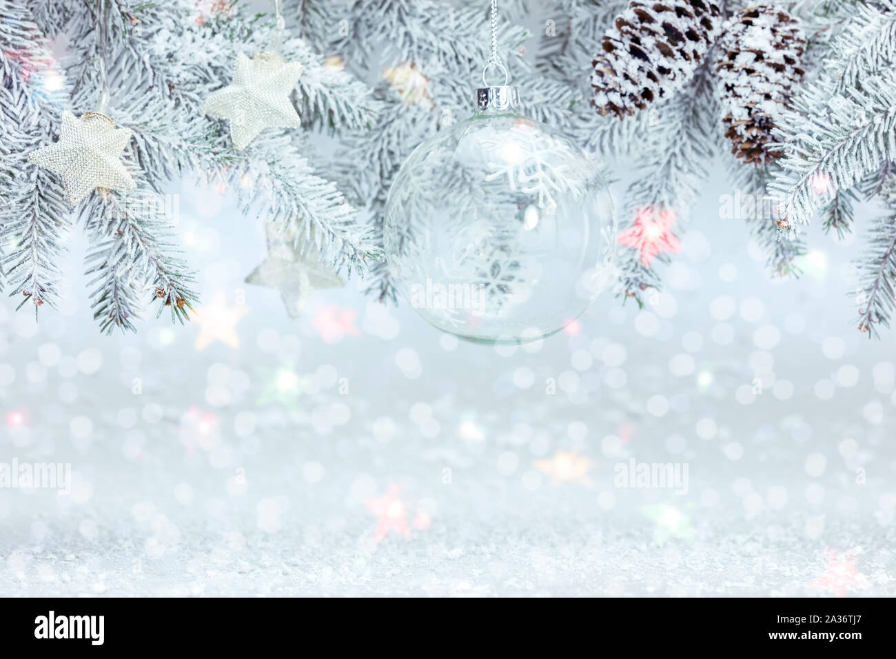 christmas tree branch decorated with glass ball and silver stars. white ...
