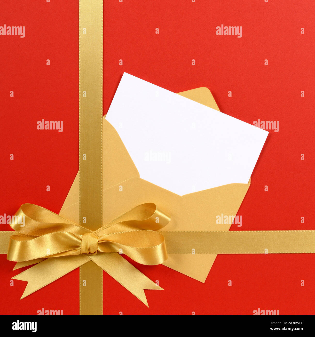 Red and gold gift with blank invitation or greetings card. Stock Photo