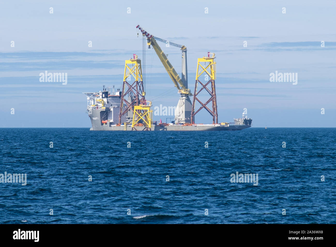 East Anglia ONE Offshore Wind Farm during construction with the heavy-lift construction vessel, Boka Lift, lifting one of the jackets in place Stock Photo
