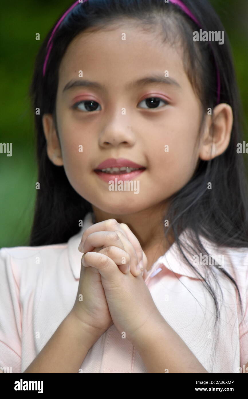 A Petite Asian Girl In Prayer Stock Photo