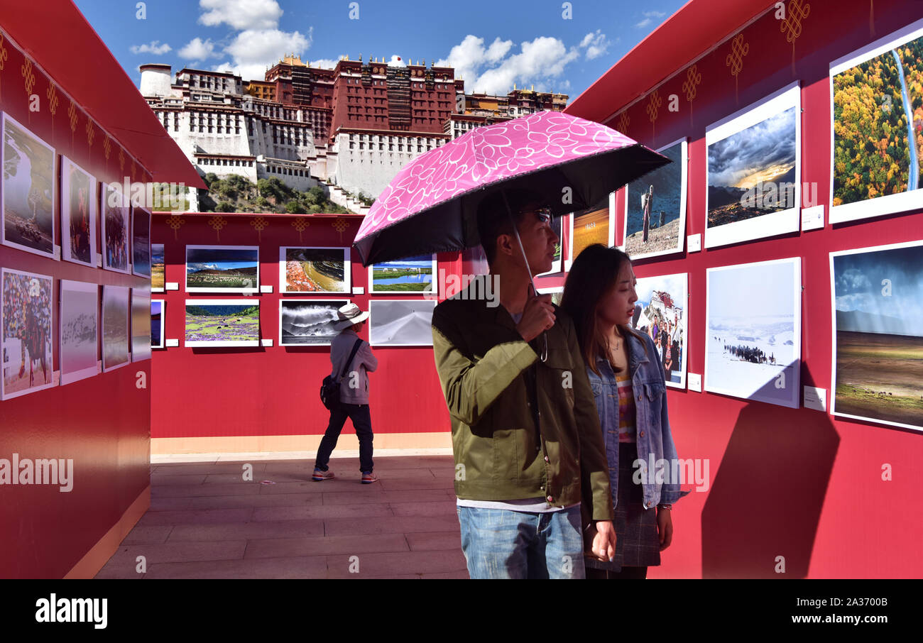 Lhasa, China's Tibet Autonomous Region. 4th Oct, 2019. Visitors view photographic works displayed during the 12th Tibet Qomolangma Photo Exhibition held on the square of the Potala Palace in Lhasa, capital of southwest China's Tibet Autonomous Region, Oct. 4, 2019. About 400 photographic works including 100 historical pictures covering a wide range of Tibetan subjects like folk-custom, culture and geography were on display during the exhibition. Credit: Zhou Jinshuai/Xinhua/Alamy Live News Stock Photo