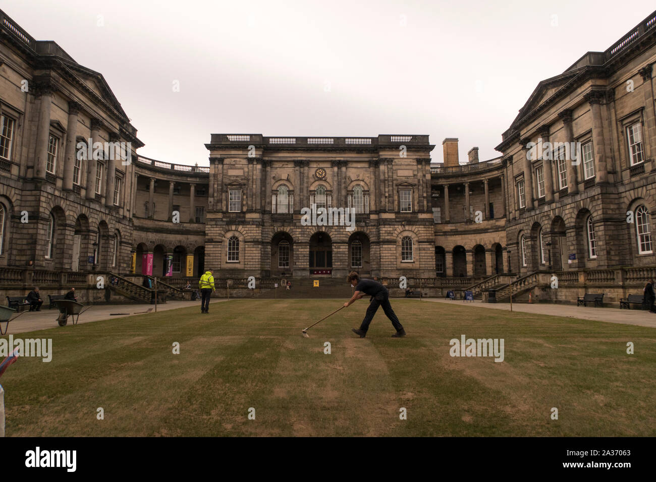 A man sweeping the grass at the University of Edinburgh Quadrangle Stock Photo