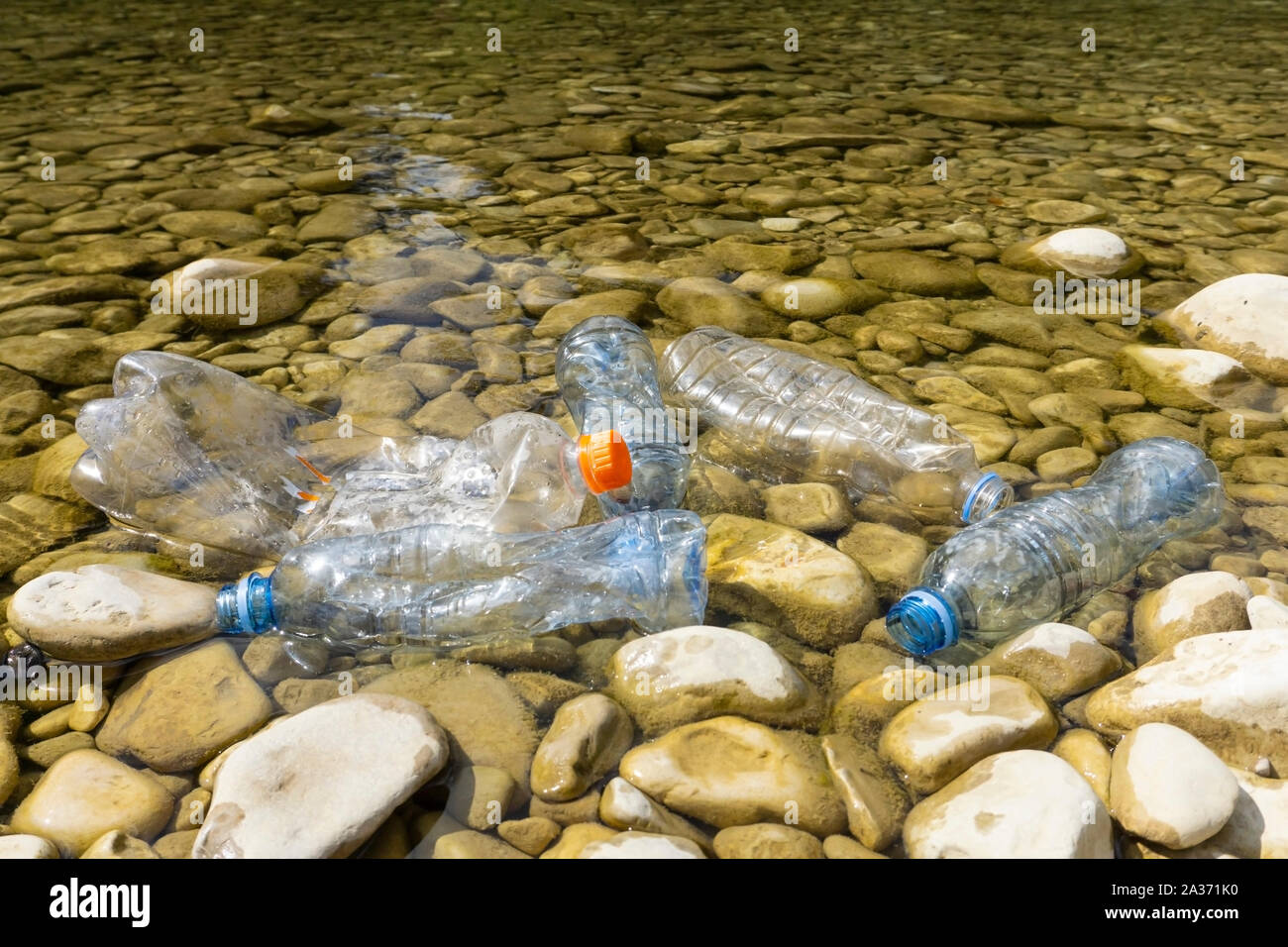 Plastic pollution in water. Dirty plastic bottles in a river. Pollution