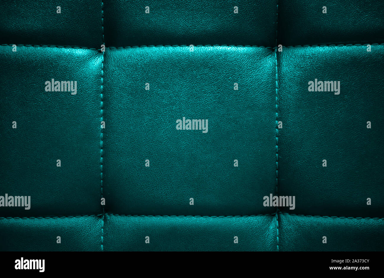 Shiny dark turquoise artificial textured leather stitched with thread. Close-up of sofa surface. View from directly above. Highly detailed background Stock Photo