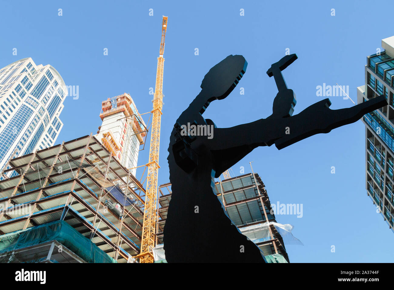 Seattle, Washington, USA. The high rise building is in the midst of construction behind the Hammering Man sculpture by Jonathan Borofsky. Stock Photo