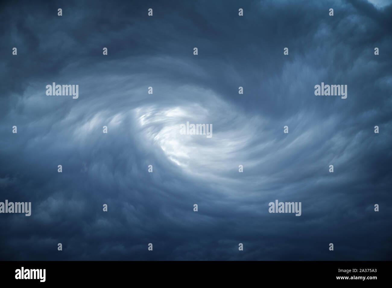 The eye of a tornado starts to create a vortex from grey couds. Stock Photo