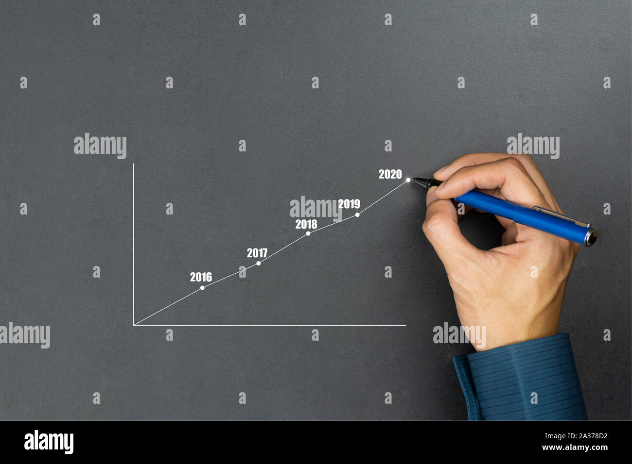 Businessman using pen drawing line year growing graph.Describe the organization's management plan or Company and development guidelines. Depicts busin Stock Photo